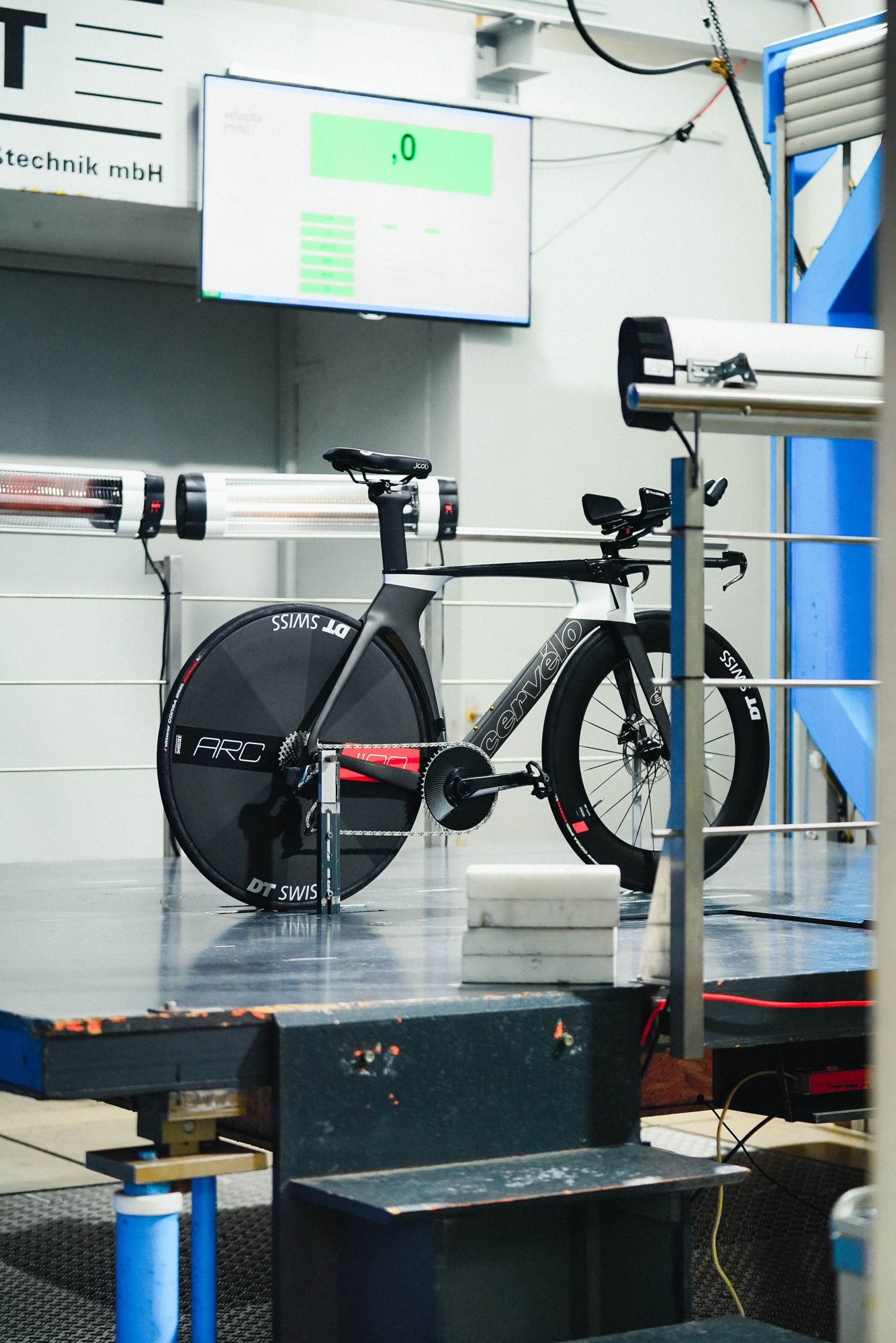 A time trial bike with a disc wheel on the balance of a wind tunnel